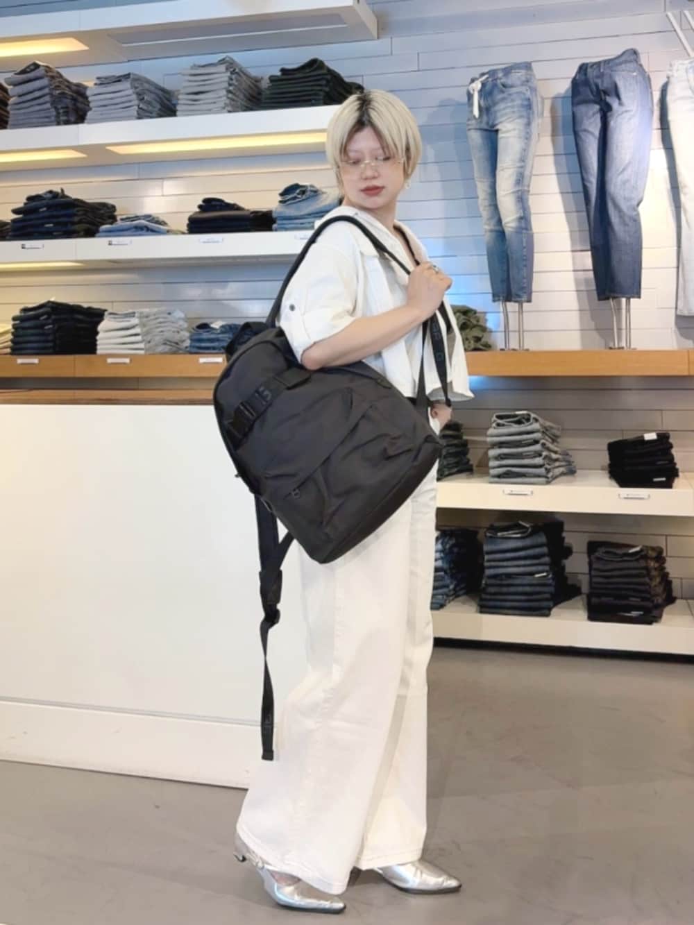 ホワイト系のシャツ/ブラウス、ホワイト系のデニムパンツ、ブラック系のバックパック/リュックを着用したレディースの春コーディネートの2枚目の写真