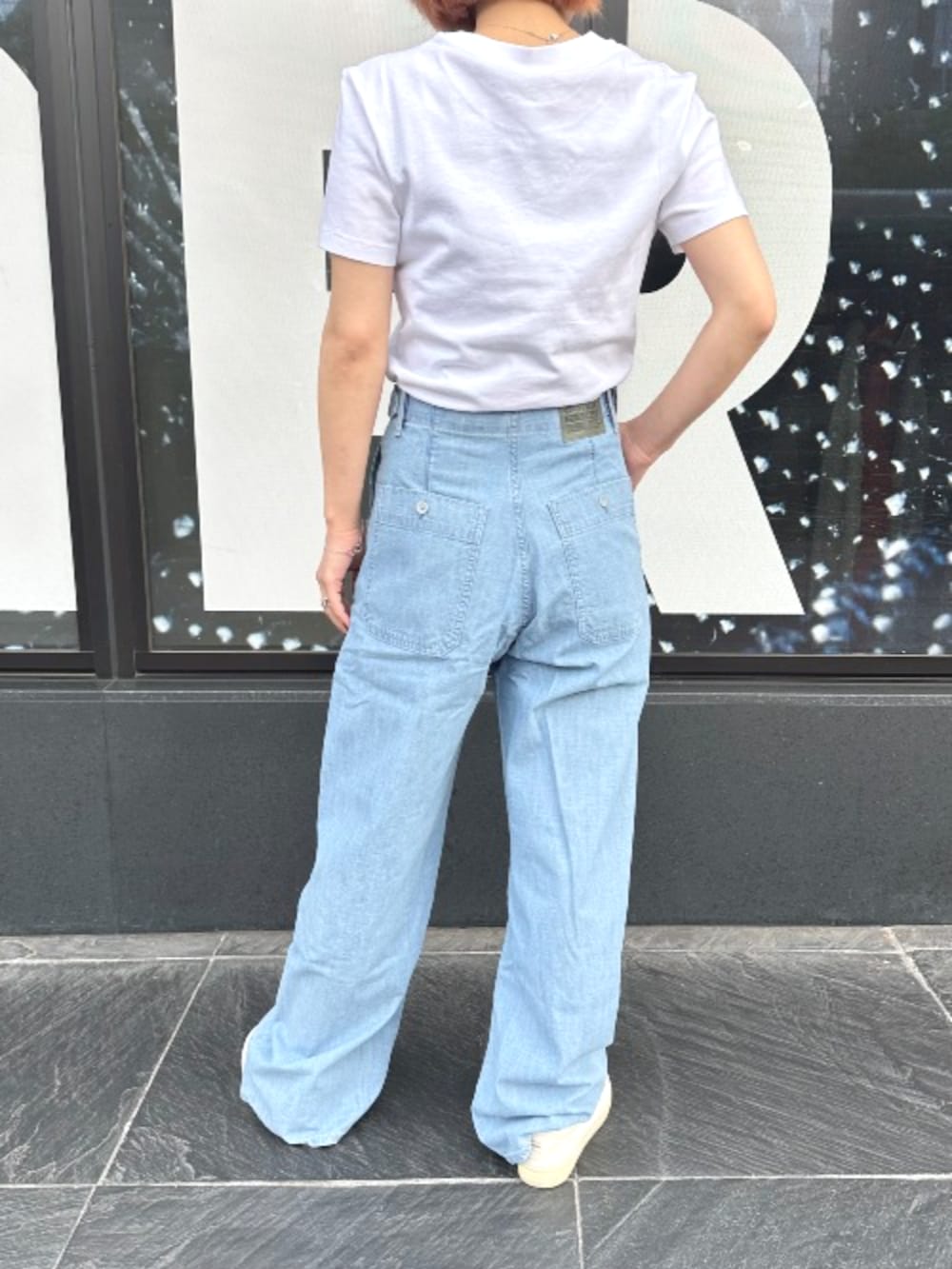 ホワイト系のTシャツ/カットソー、ブルー系のデニムパンツ、ブラウン系のベルトを着用したレディースの春コーディネートの2枚目の写真