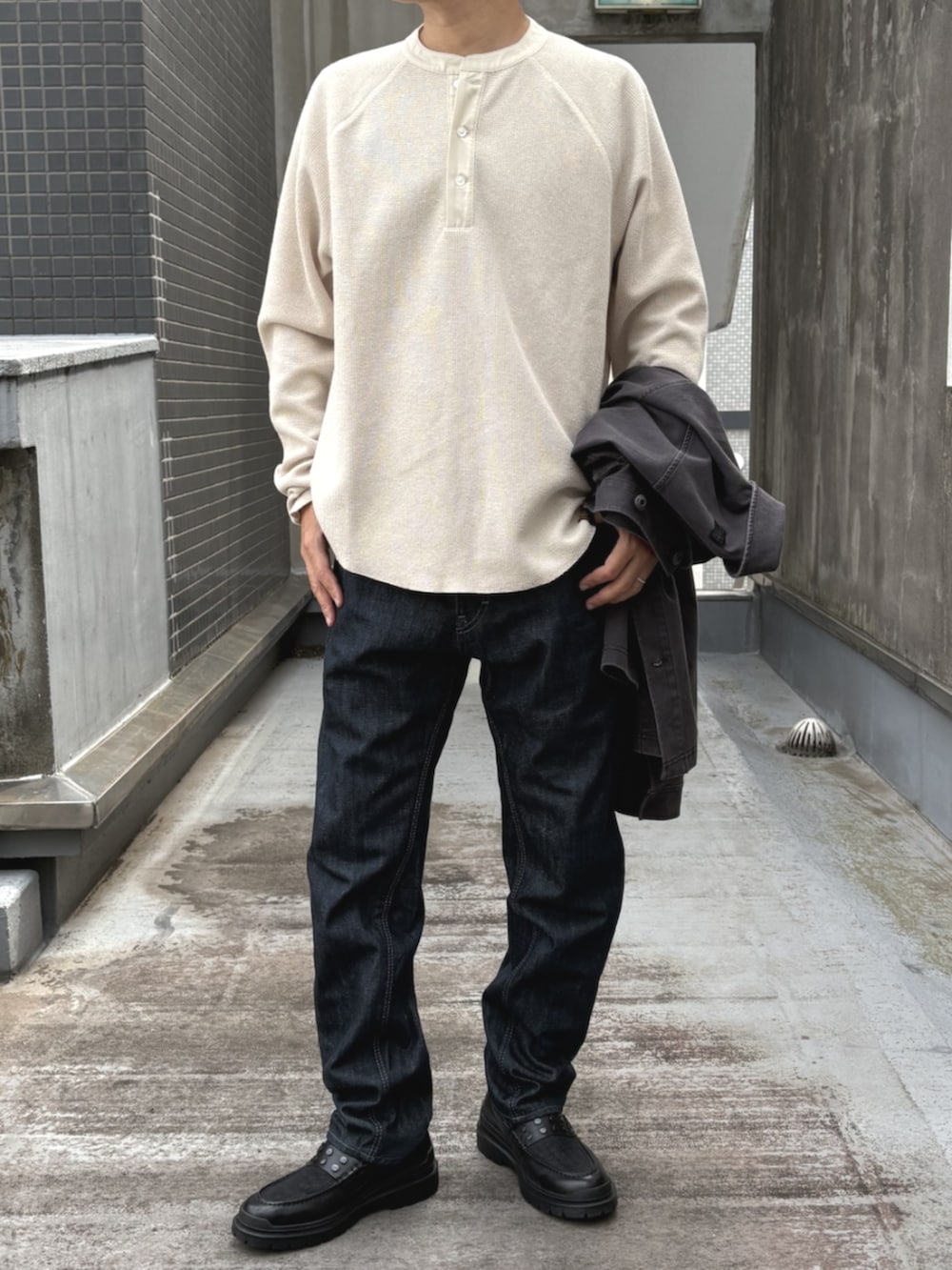 ブラック系のローファー、ホワイト系のTシャツ/カットソー、ブルー系のデニムパンツを着用したメンズの秋コーディネートの2枚目の写真