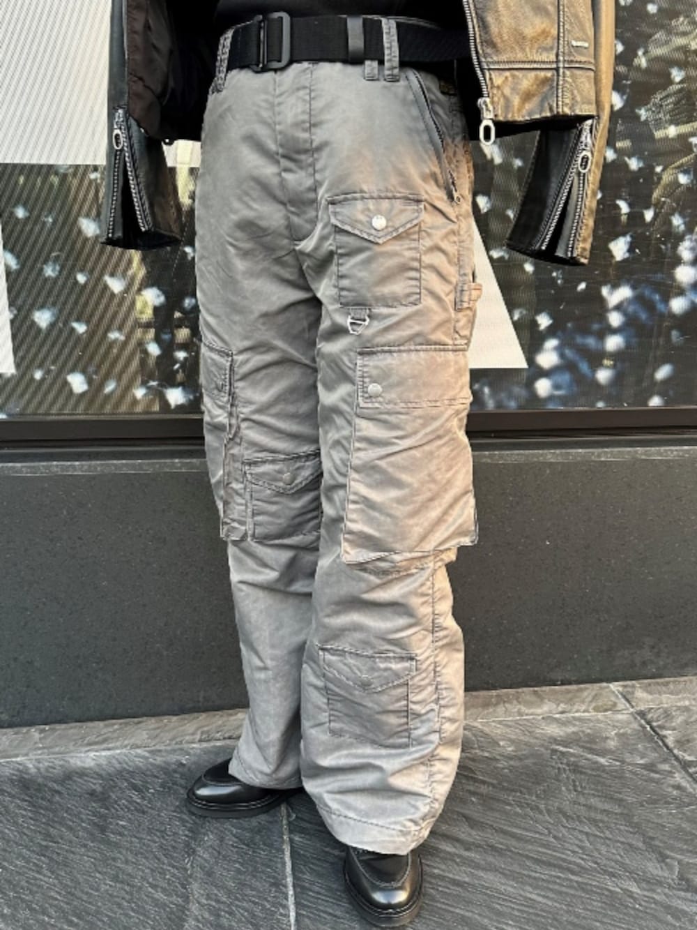 ブラック系のライダースジャケット、ブラック系のTシャツ/カットソー、グレー系のカーゴパンツを着用したレディースの秋コーディネートの2枚目の写真