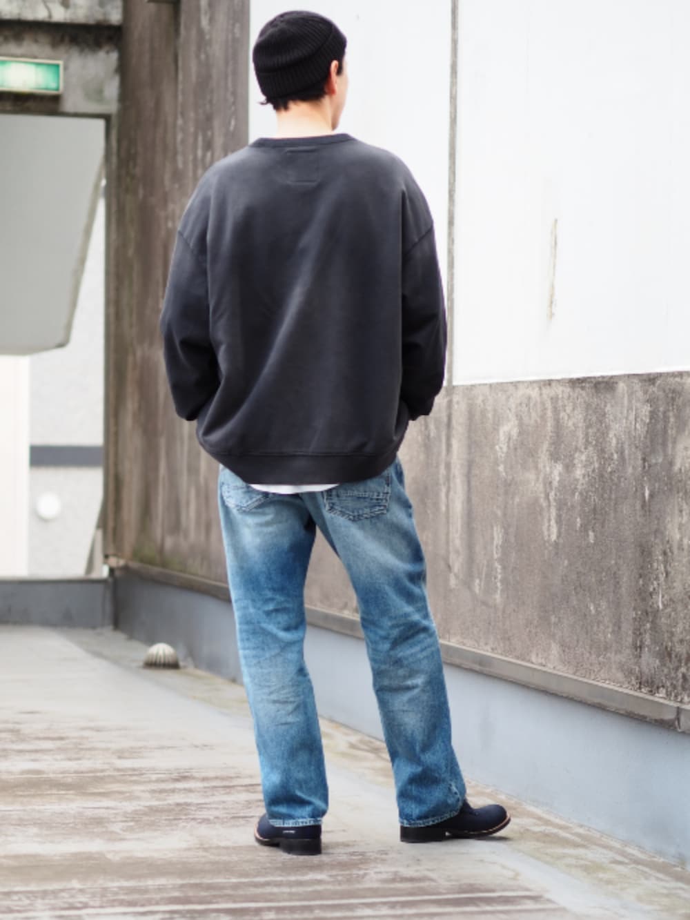 ブルー系のデニムパンツ、ブラック系のスウェットを着用したメンズの春コーディネートの2枚目の写真
