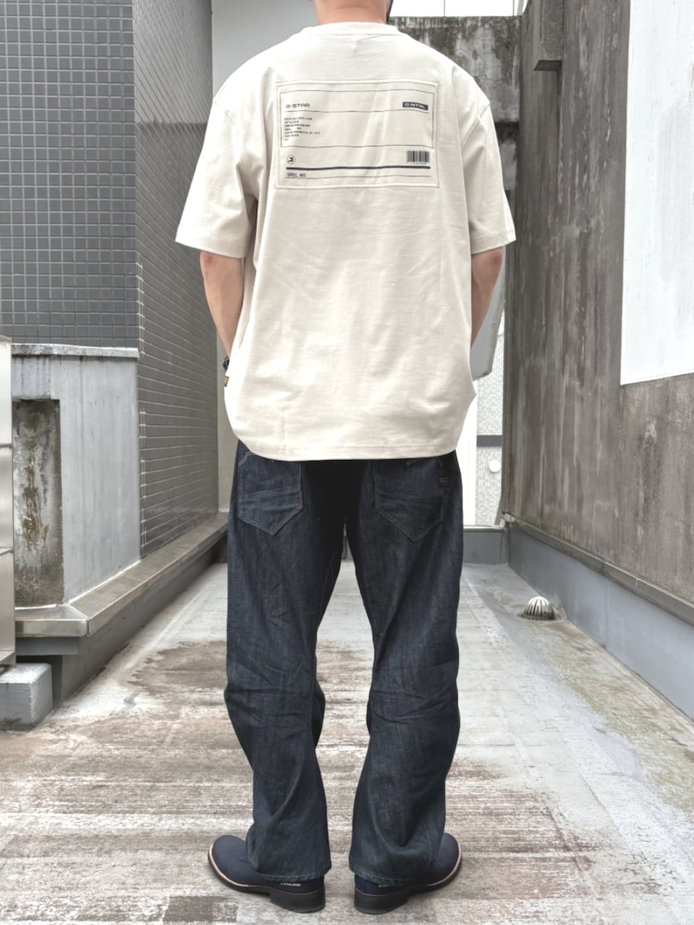 ブルー系のデニムパンツ、ホワイト系のTシャツ/カットソーを着用したメンズの秋コーディネートの2枚目の写真
