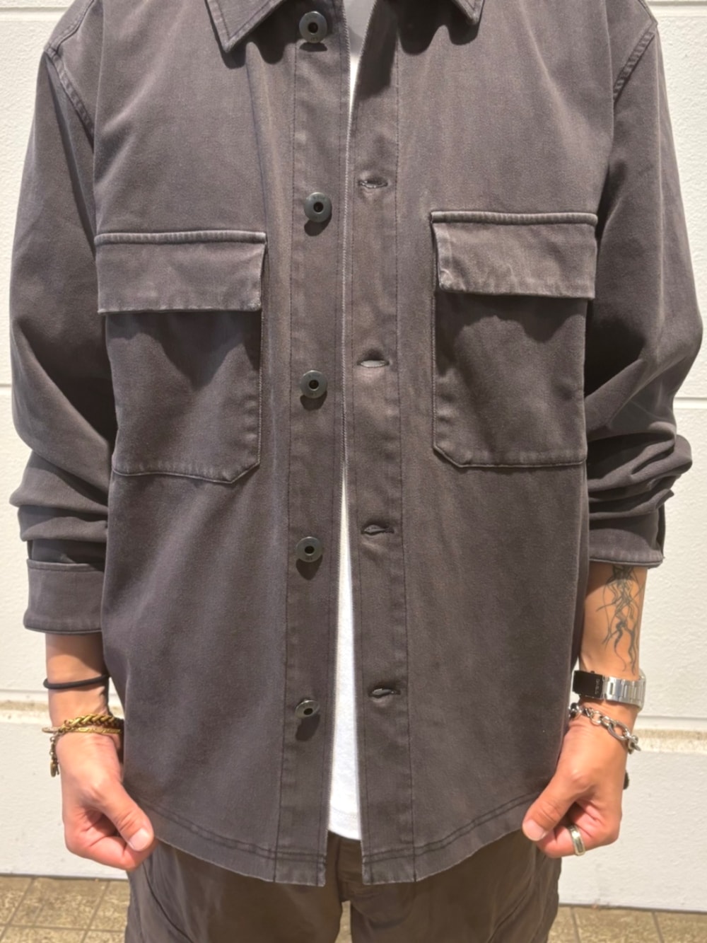 ホワイト系のTシャツ/カットソー、ブラック系のシャツ/ブラウス、ブラウン系のカーゴパンツを着用したメンズの秋コーディネートの2枚目の写真