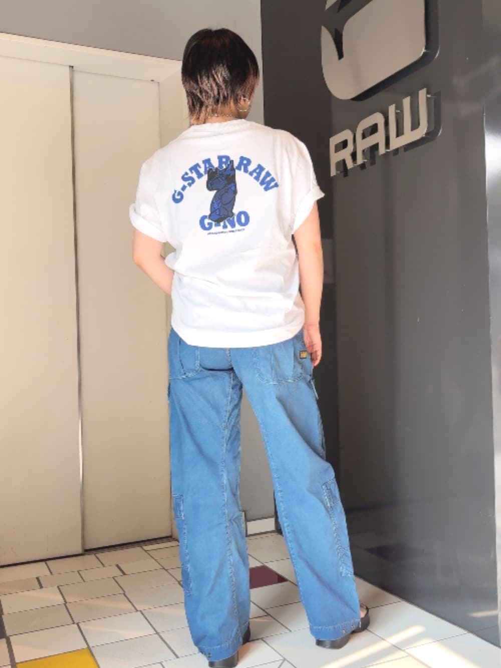 ホワイト系のTシャツ/カットソー、ブルー系のデニムパンツを着用したレディースの夏コーディネートの2枚目の写真