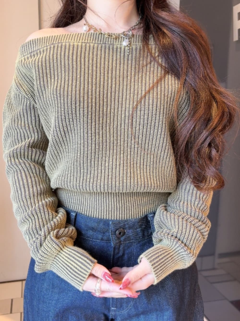 ブラウン系のニット/セーター、ブルー系のデニムパンツを着用したレディースの冬コーディネートの3枚目の写真