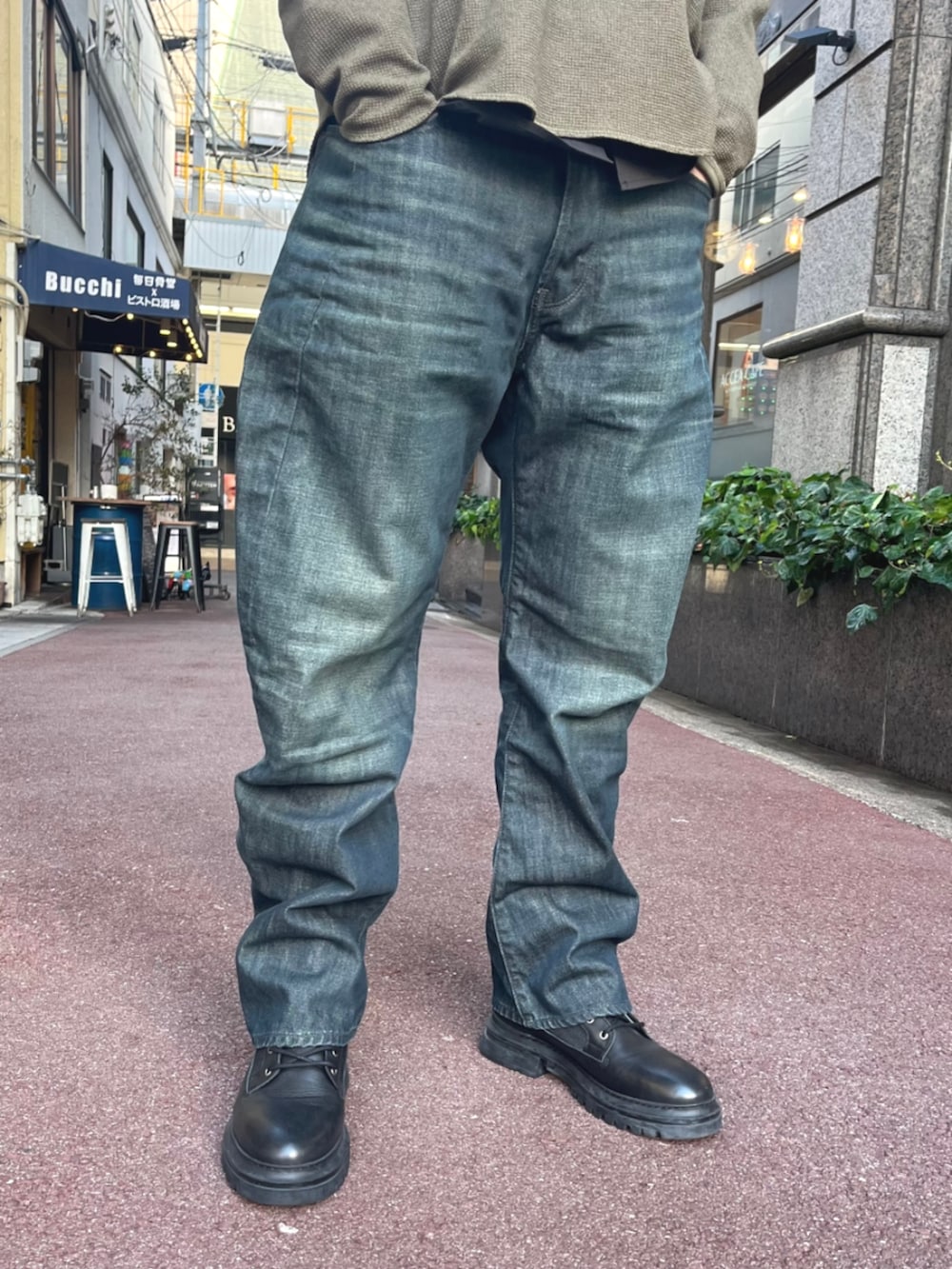 ブラック系のシャツ/ブラウス、グリーン系のTシャツ/カットソー、ブルー系のデニムパンツを着用したメンズの秋コーディネートの2枚目の写真