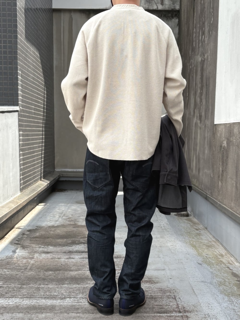 ホワイト系のTシャツ/カットソー、ブルー系のデニムパンツを着用したメンズの秋コーディネートの3枚目の写真