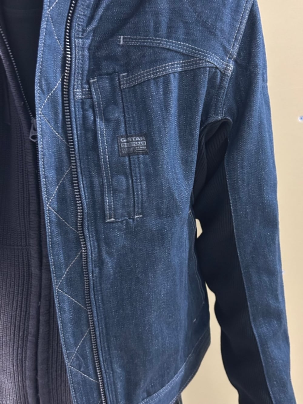 ブルー系のニット/セーター、ブルー系のデニムジャケット、ブルー系のデニムパンツを着用したメンズの春コーディネートの3枚目の写真