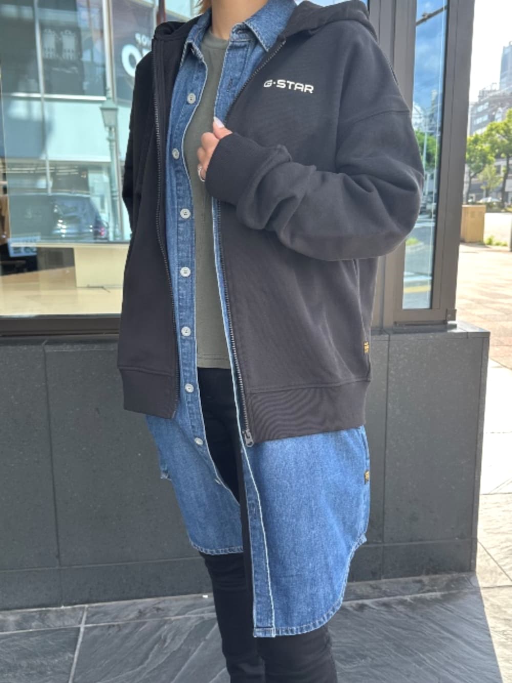 ブラック系のデニムパンツ、ブラック系のパーカーを着用したレディースの秋コーディネートの2枚目の写真