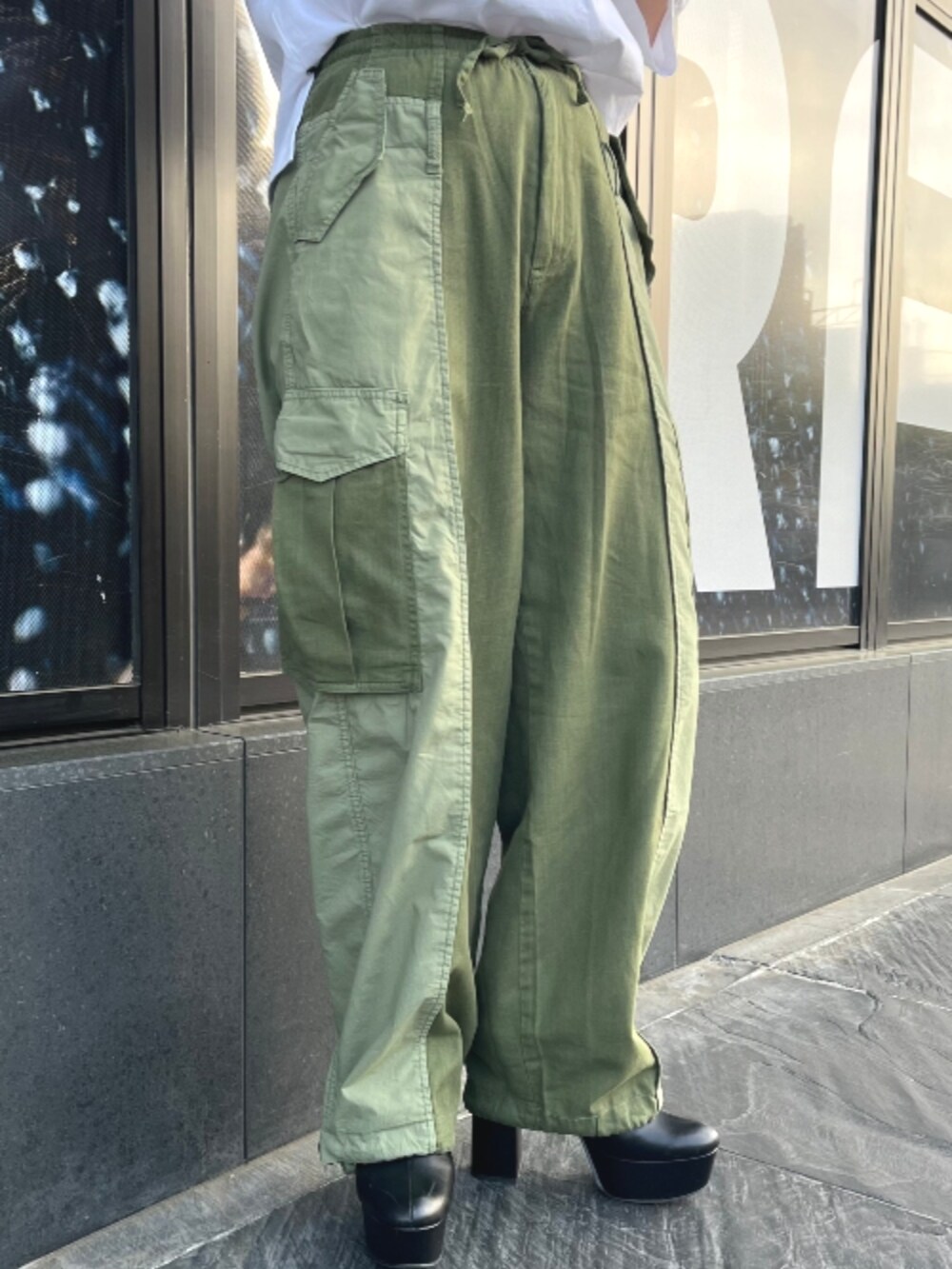 グリーン系のカーゴパンツ、ホワイト系のTシャツ/カットソーを着用したレディースの春コーディネートの3枚目の写真