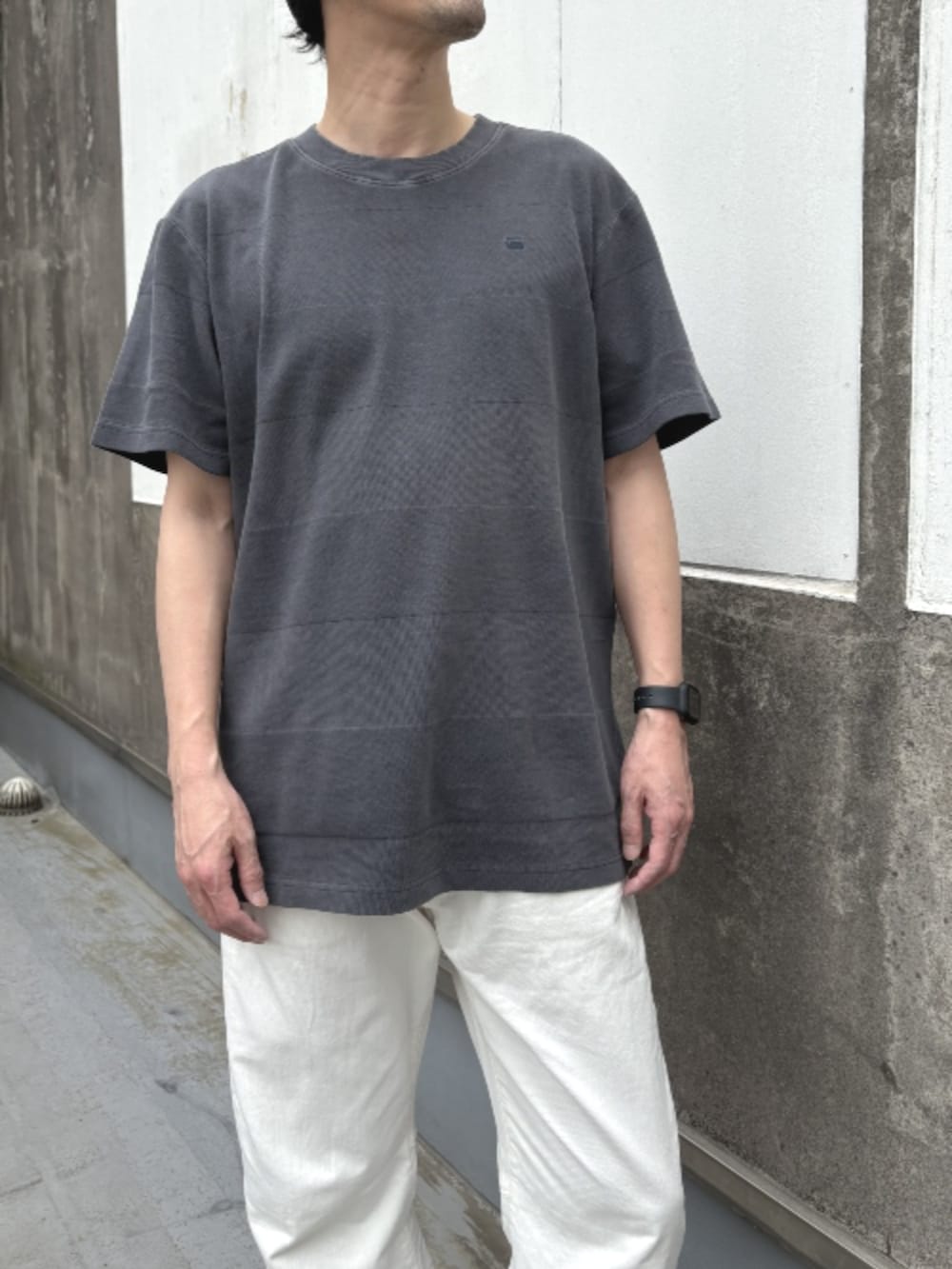 グレー系のTシャツ/カットソー、ベージュ系のデニムパンツを着用したメンズの春コーディネートの2枚目の写真