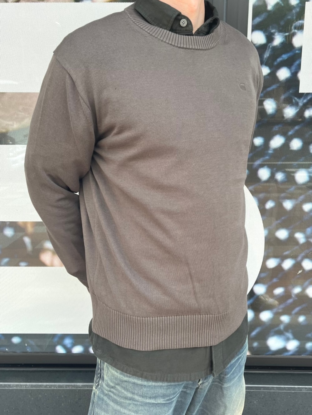 ブラウン系のニット/セーター、ブルー系のシャツ/ブラウス、ブルー系のデニムパンツを着用したメンズの夏コーディネートの3枚目の写真