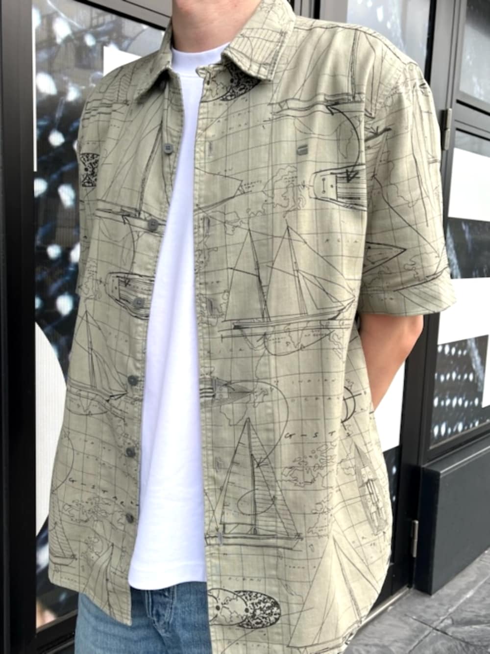 ホワイト系のTシャツ/カットソー、グリーン系のシャツ/ブラウス、ブルー系のデニムパンツを着用したメンズの夏コーディネートの2枚目の写真