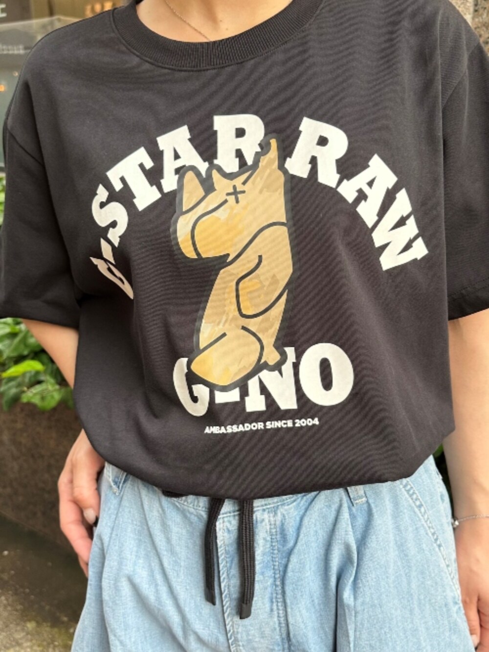 ブラック系のTシャツ/カットソー、ブルー系のデニムパンツを着用したレディースの夏コーディネートの2枚目の写真