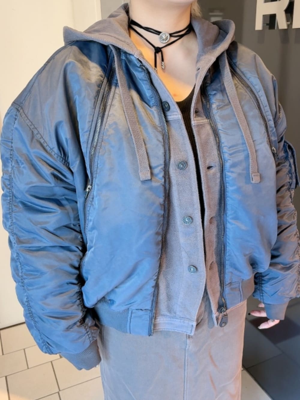 ブルー系のMA-1、グレー系のパーカーを着用したレディースの秋コーディネートの2枚目の写真