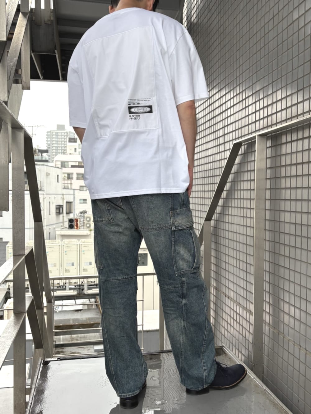 ブルー系のデニムパンツ、ホワイト系のTシャツ/カットソーを着用したメンズの春コーディネートの2枚目の写真