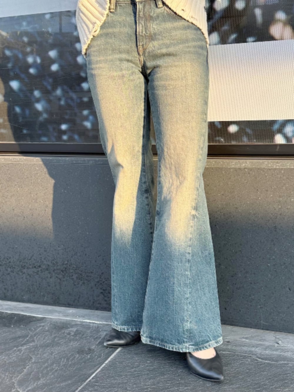 ベージュ系のニット/セーター、ブルー系のデニムパンツを着用したレディースの春コーディネートの3枚目の写真