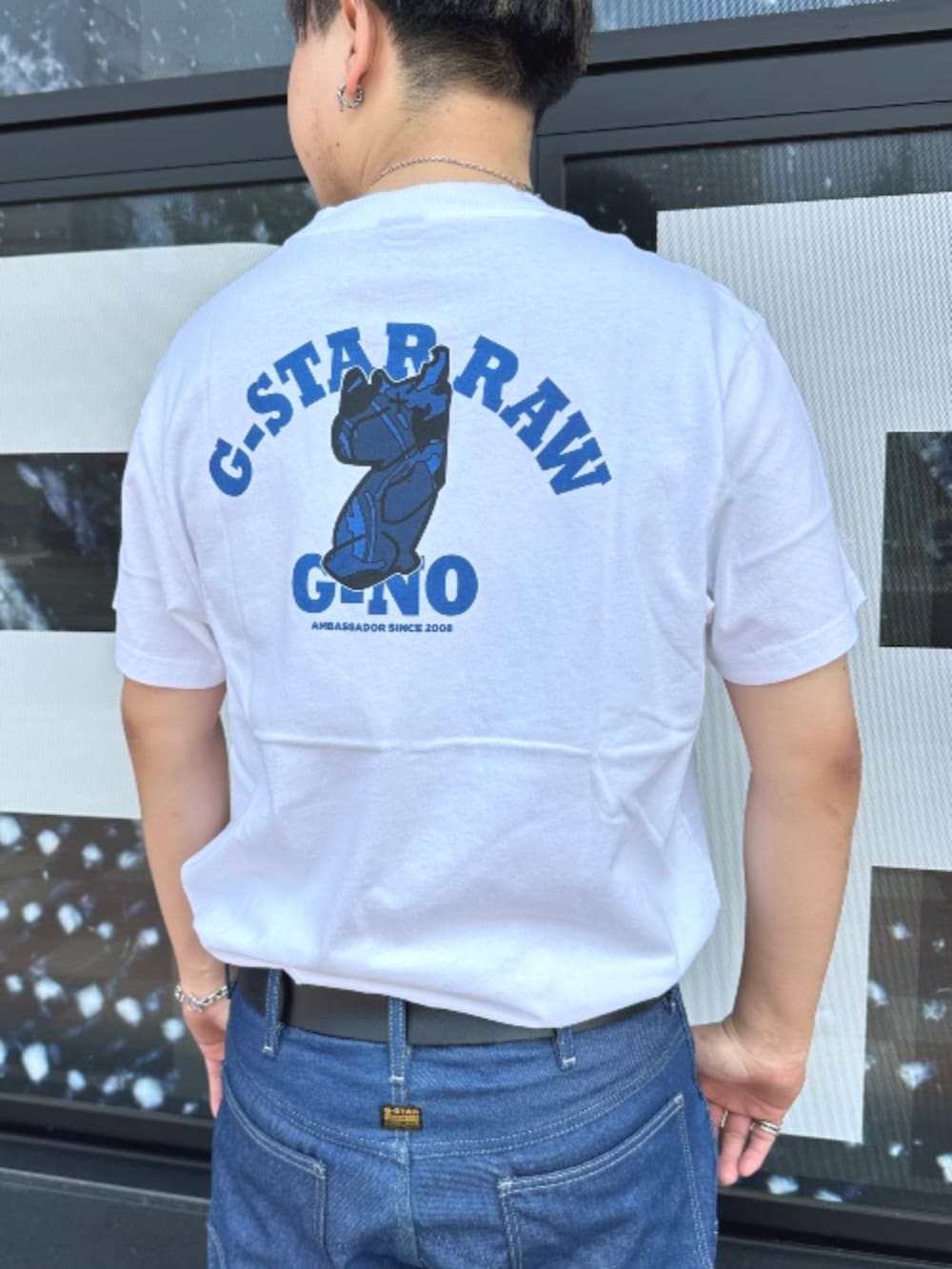 ホワイト系のTシャツ/カットソー、ブルー系のデニムパンツを着用したメンズの夏コーディネートの3枚目の写真