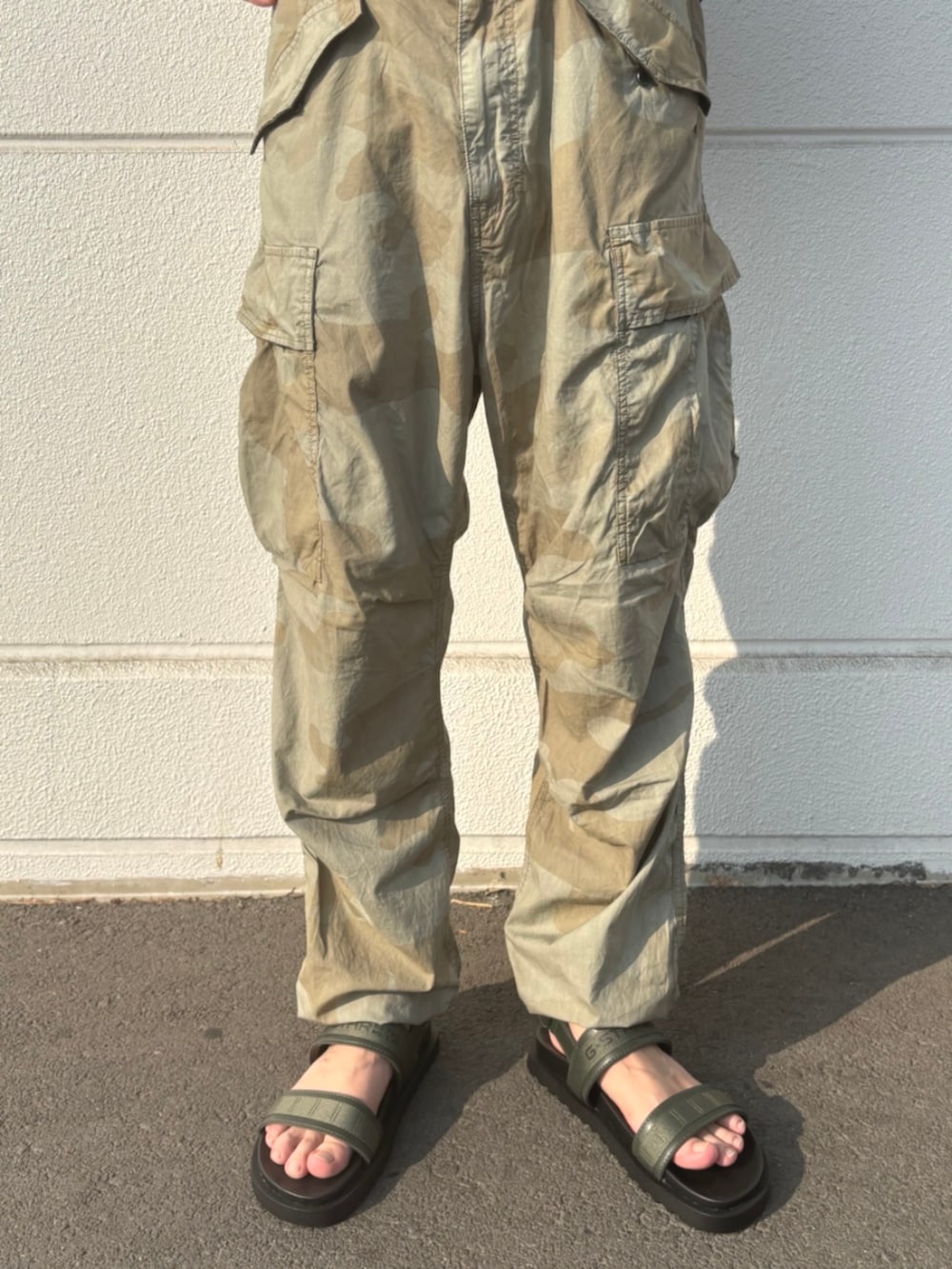 ブラック系のTシャツ/カットソー、その他のカーゴパンツ、ブラック系のサンダルを着用したメンズの夏コーディネートの3枚目の写真
