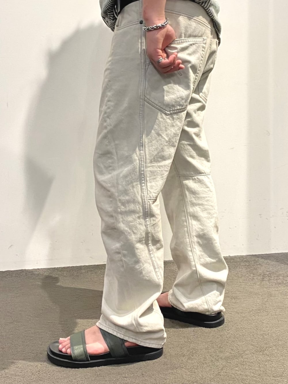 グレー系のデニムパンツ、グリーン系のシャツ/ブラウス、ブラック系のサンダルを着用したメンズの夏コーディネートの3枚目の写真