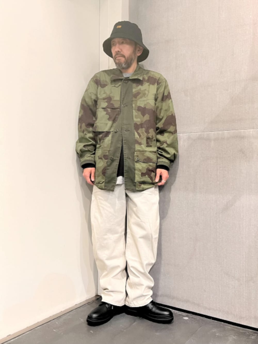グリーン系のミリタリージャケット、グレー系のデニムパンツを着用したメンズの春コーディネートの2枚目の写真