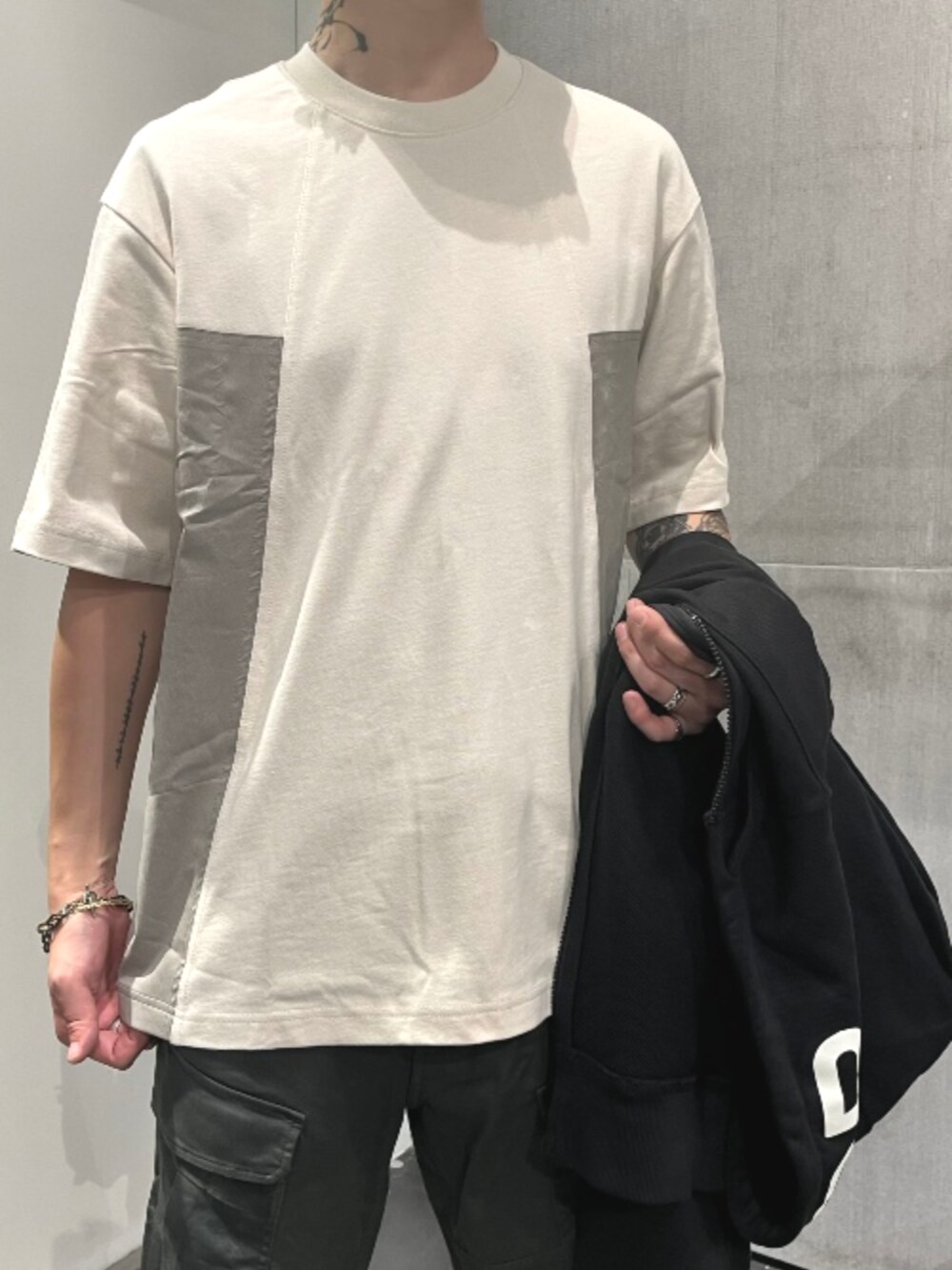 グリーン系のカーゴパンツ、ブラック系のパーカーを着用したメンズの秋コーディネートの4枚目の写真