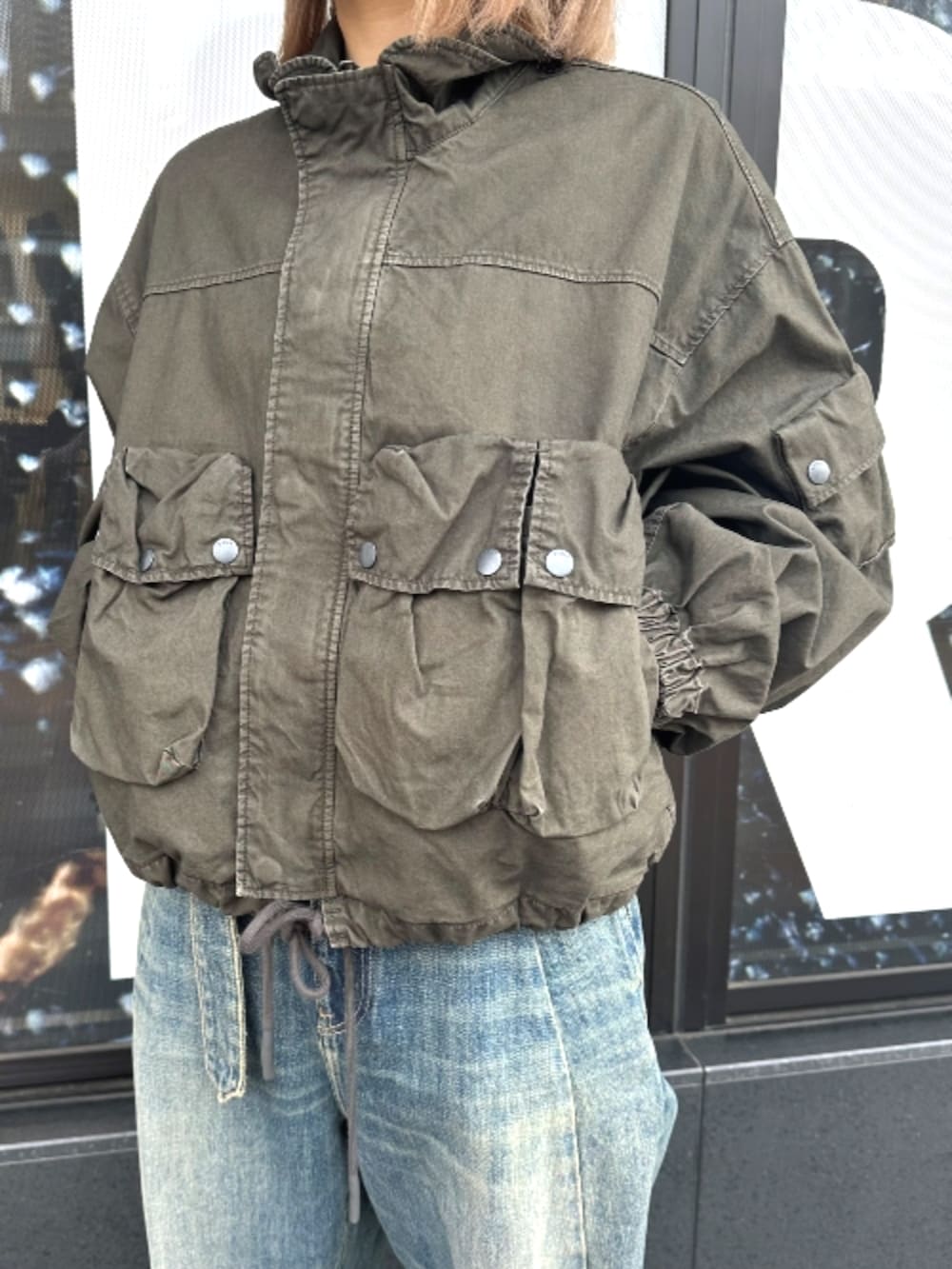 ブラウン系のTシャツ/カットソー、グリーン系のブルゾンを着用したレディースの春コーディネートの2枚目の写真