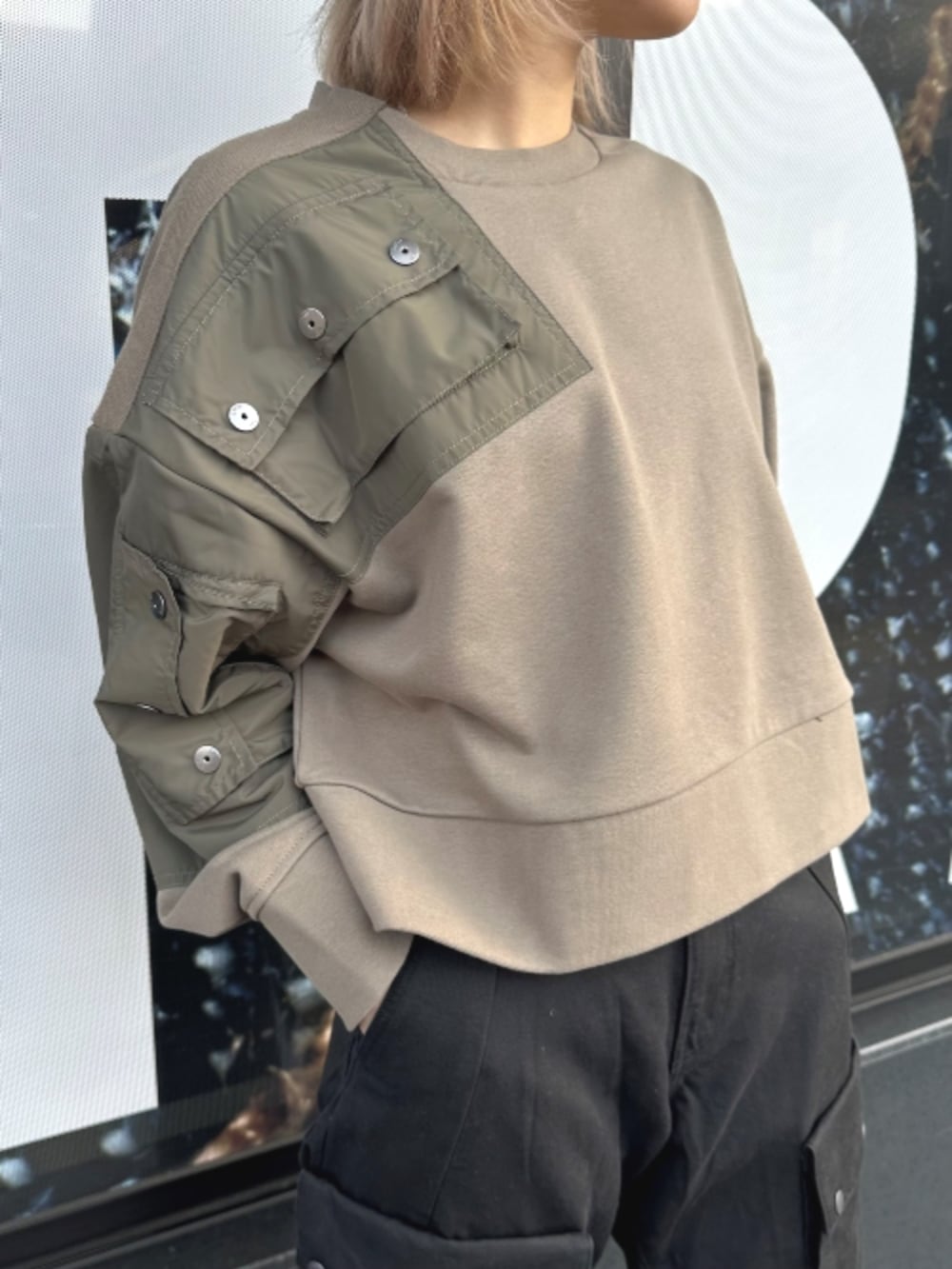 ブラウン系のスウェット、ブラック系のカーゴパンツを着用したレディースの春コーディネートの2枚目の写真