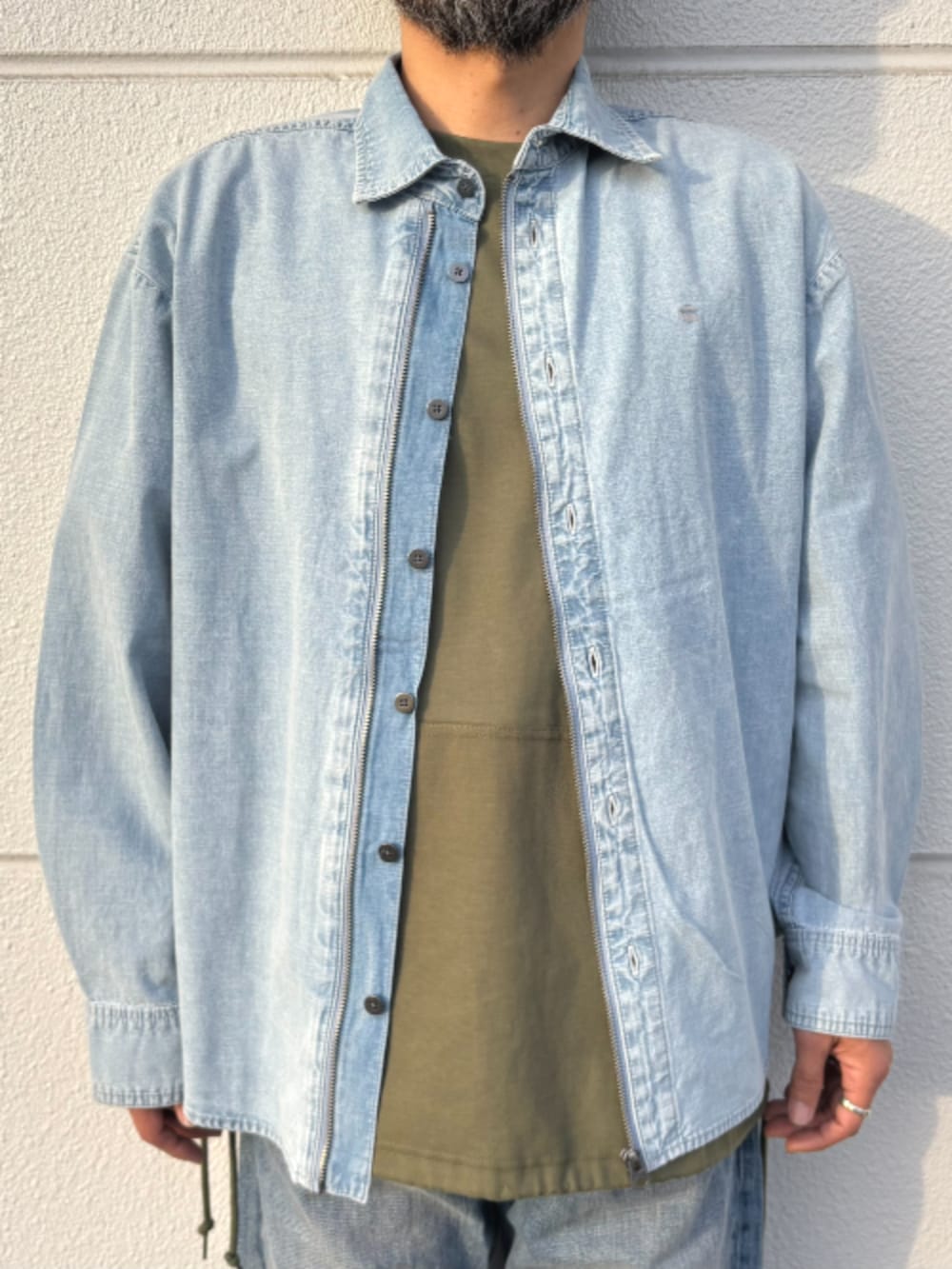 ブルー系のシャツ/ブラウス、グリーン系のTシャツ/カットソー、ブルー系のデニムパンツを着用したメンズの春コーディネートの3枚目の写真