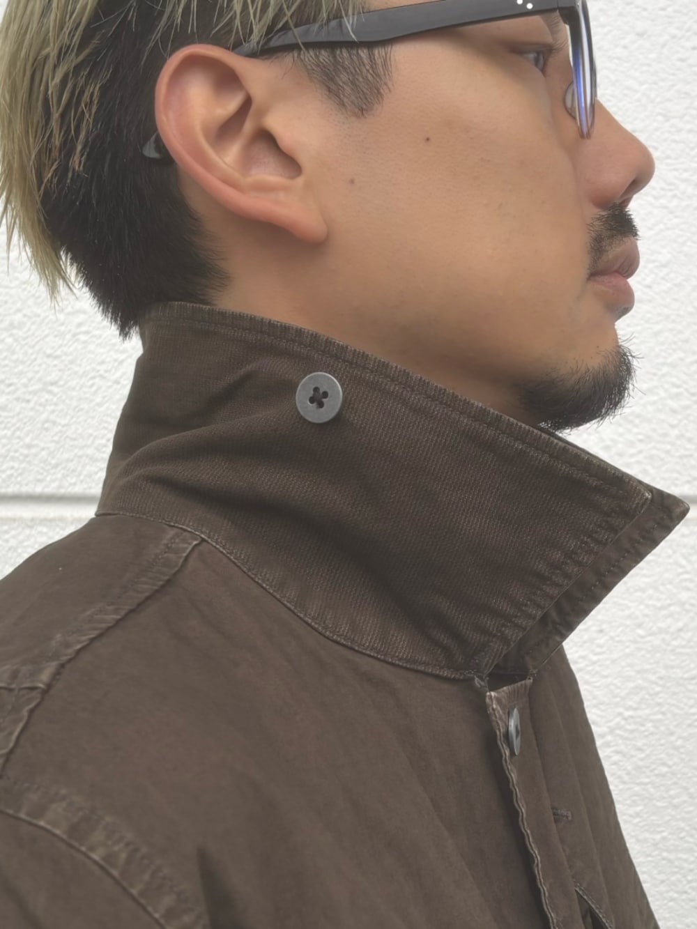 ブラック系のドレスシューズ、ブルー系のデニムパンツ、グリーン系のミリタリージャケットを着用したメンズの秋コーディネートの4枚目の写真