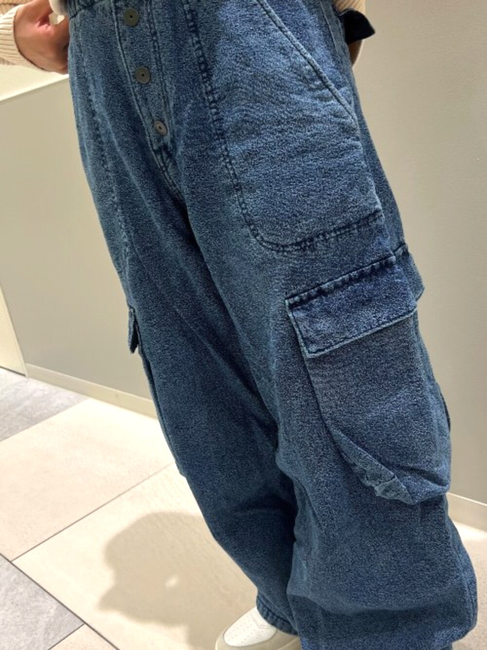 ブルー系のデニムパンツを着用したレディースの秋コーディネートの2枚目の写真