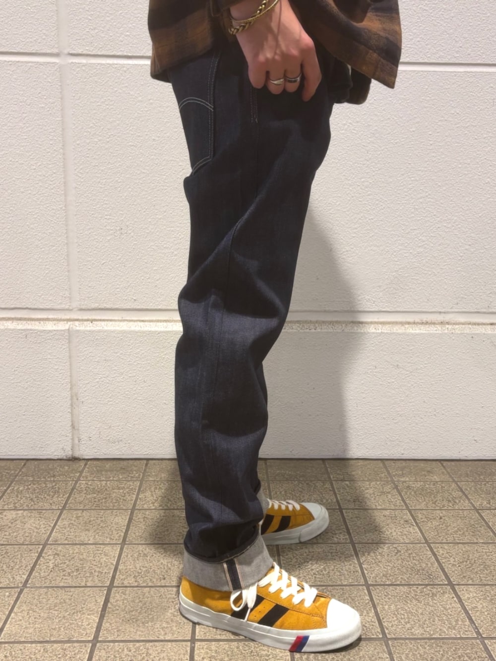 ブラウン系のシャツ/ブラウス、ホワイト系のニット/セーター、ブルー系のデニムパンツを着用したメンズの秋コーディネートの3枚目の写真