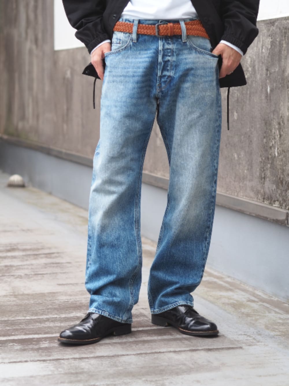 ブラック系のナイロンジャケット、ブルー系のデニムパンツ、ホワイト系のTシャツ/カットソーを着用したメンズの春コーディネートの3枚目の写真