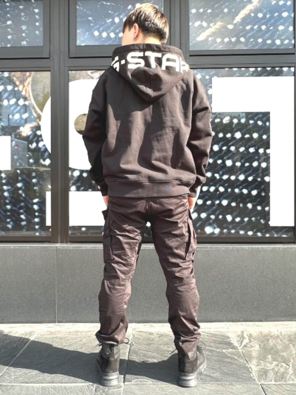 ブラック系のカーゴパンツ、ブラック系のパーカーを着用したメンズの秋コーディネートの2枚目の写真