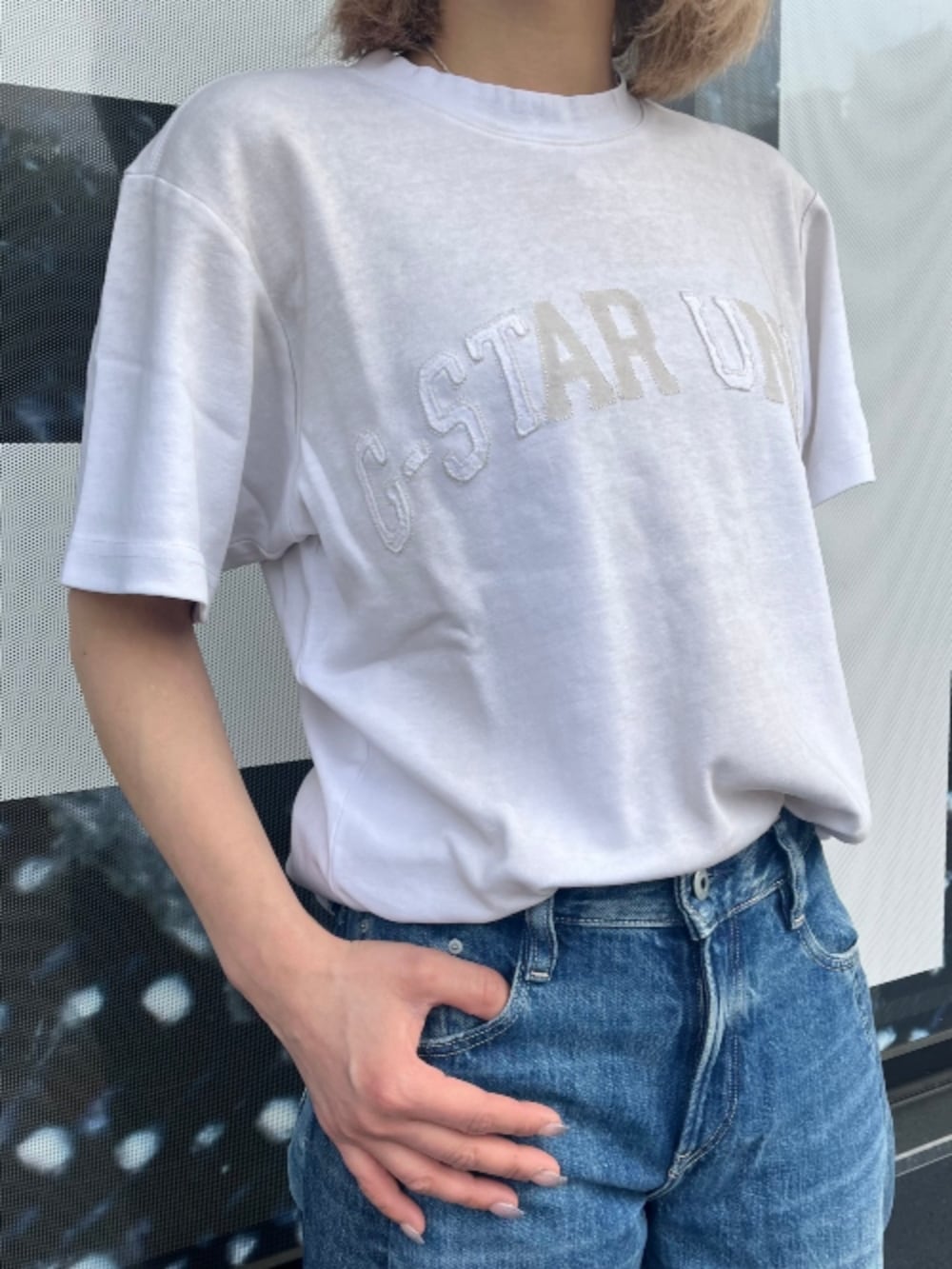 ホワイト系のTシャツ/カットソー、ブルー系のデニムパンツを着用したレディースの春コーディネートの2枚目の写真