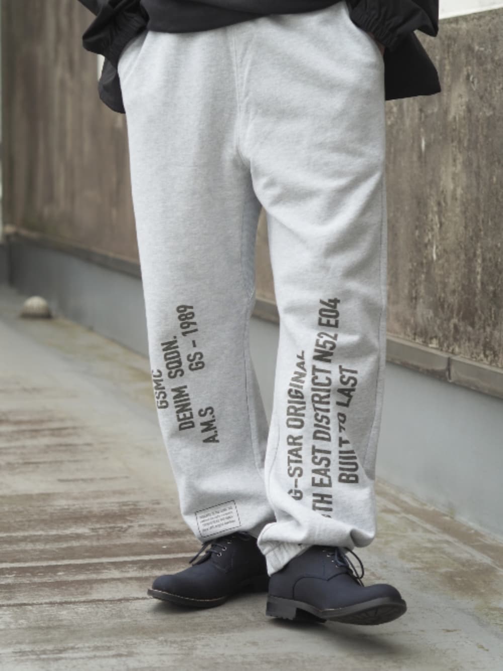 ブラック系のナイロンジャケット、グレー系のスウェットパンツを着用したメンズの春コーディネートの4枚目の写真