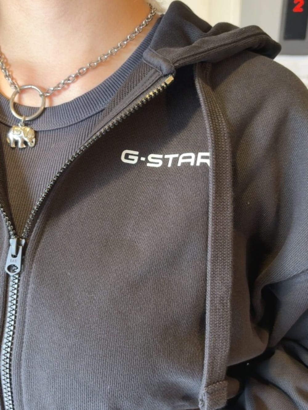 ブラック系のパーカー、ブルー系のデニムスカートを着用したレディースの秋コーディネートの3枚目の写真