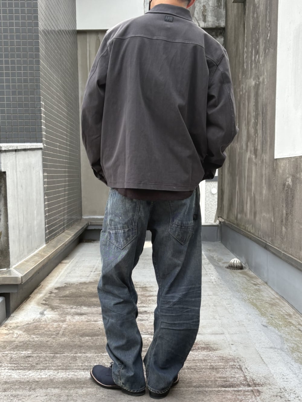 ブルー系のデニムパンツ、ブラック系のシャツ/ブラウスを着用したメンズの秋コーディネートの3枚目の写真