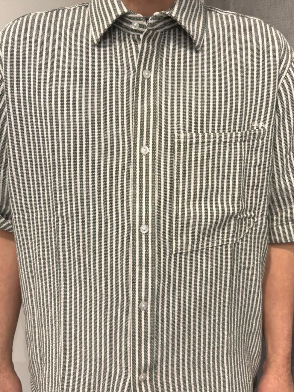 グリーン系のシャツ/ブラウス、ブルー系のデニムパンツ、グレー系のTシャツ/カットソーを着用したメンズの春コーディネートの3枚目の写真