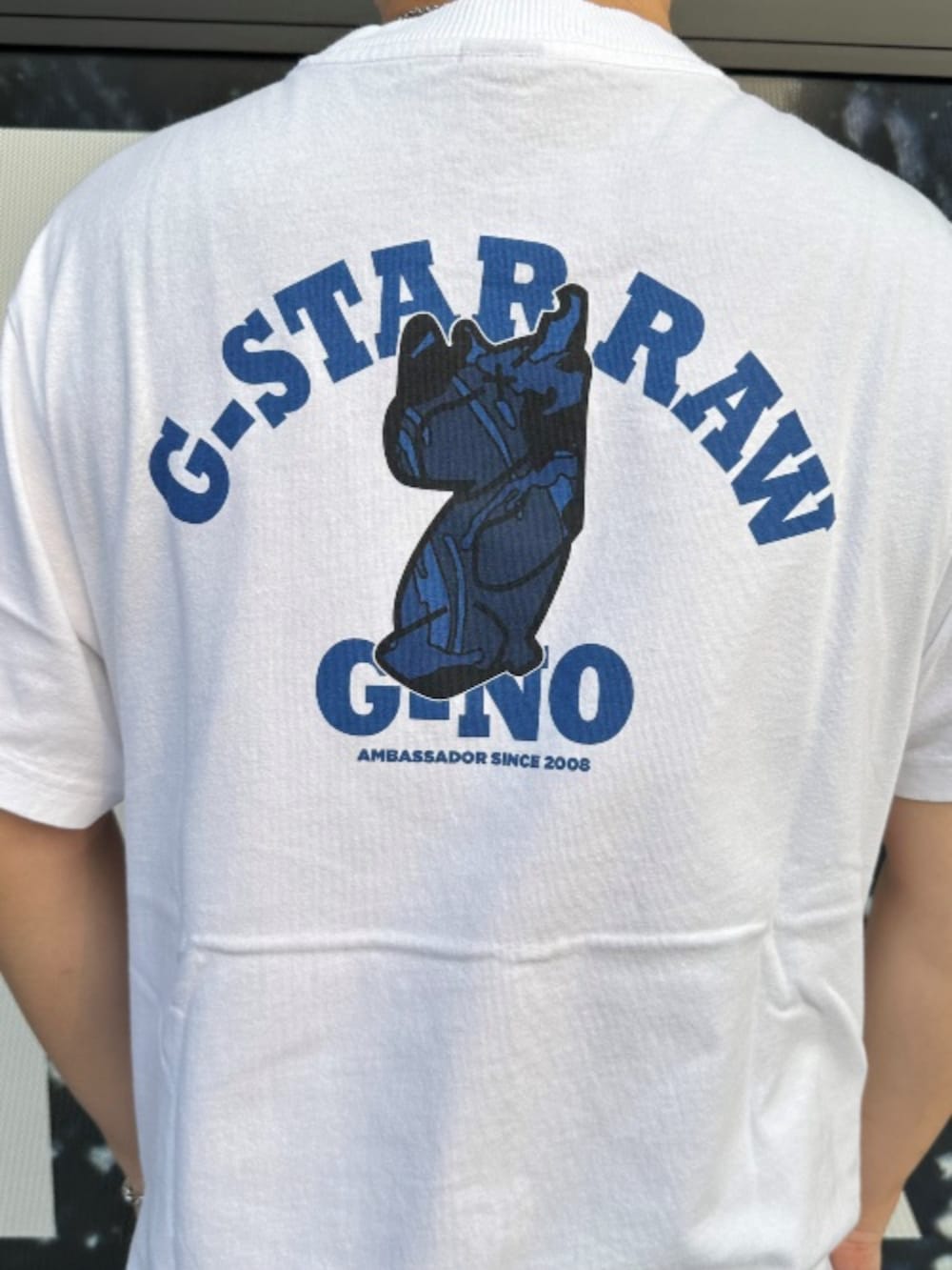 ホワイト系のTシャツ/カットソー、ブルー系のデニムパンツを着用したメンズの夏コーディネートの3枚目の写真