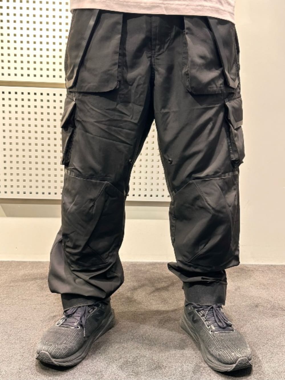 ホワイト系のTシャツ/カットソー、ブラック系のナイロンジャケット、ブラック系のカーゴパンツを着用したメンズの秋コーディネートの3枚目の写真