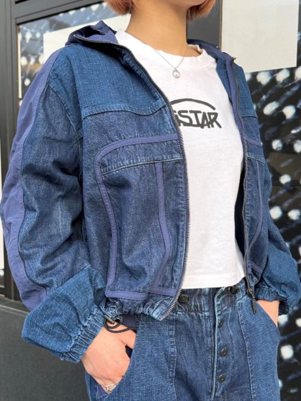 ブルー系のブルゾン、ホワイト系のTシャツ/カットソー、ブルー系のデニムパンツを着用したレディースの春コーディネートの2枚目の写真