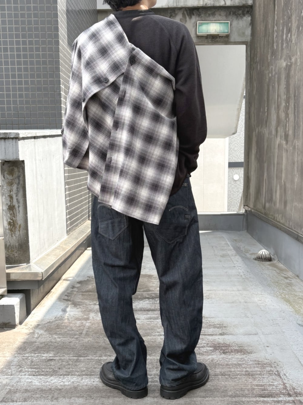 ブラック系のローファー、ブラック系のTシャツ/カットソー、ブルー系のデニムパンツを着用したメンズの秋コーディネートの2枚目の写真