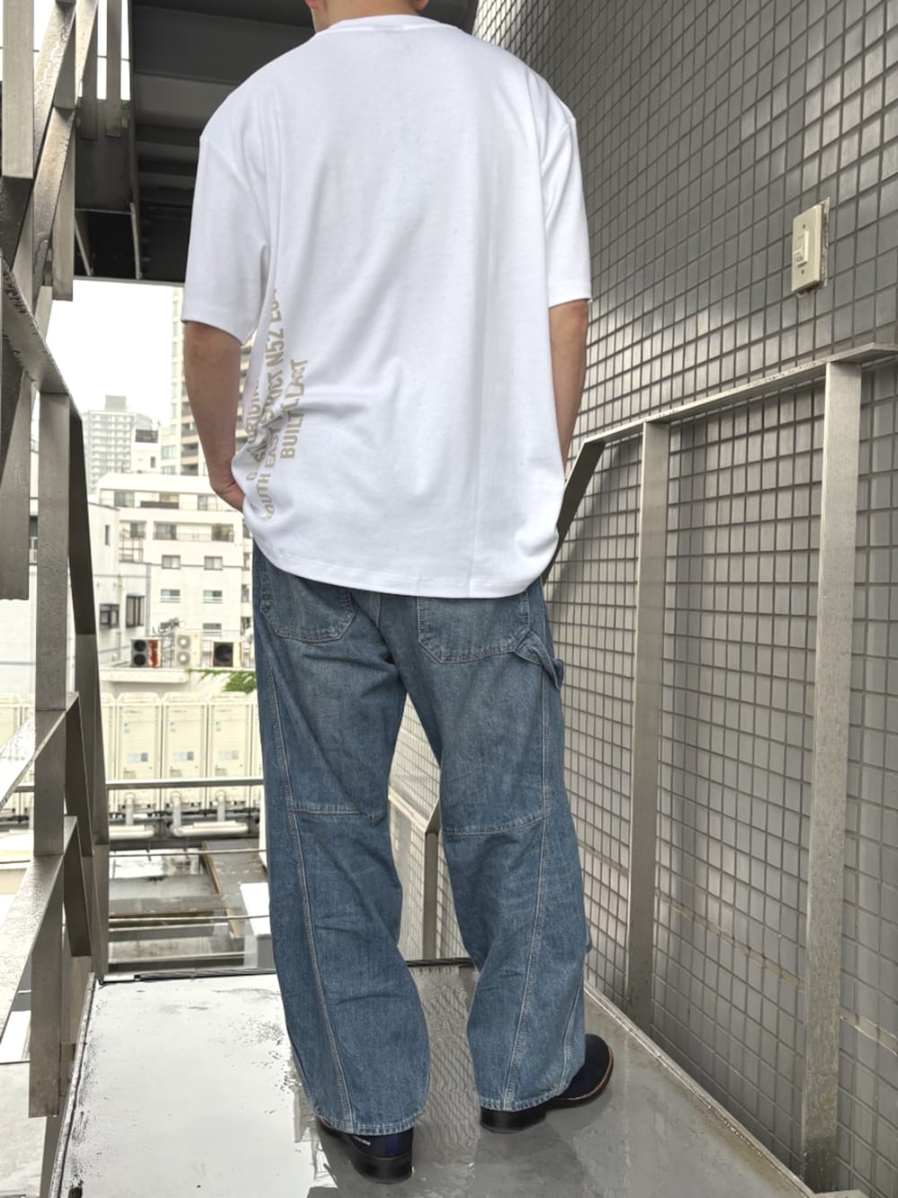 ブルー系のデニムパンツ、ホワイト系のTシャツ/カットソーを着用したメンズの夏コーディネートの2枚目の写真