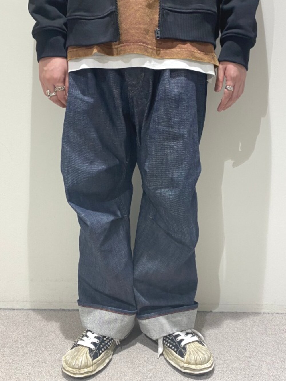 ブラック系のパーカー、ブラウン系のTシャツ/カットソー、ブルー系のデニムパンツを着用したメンズの秋コーディネートの4枚目の写真