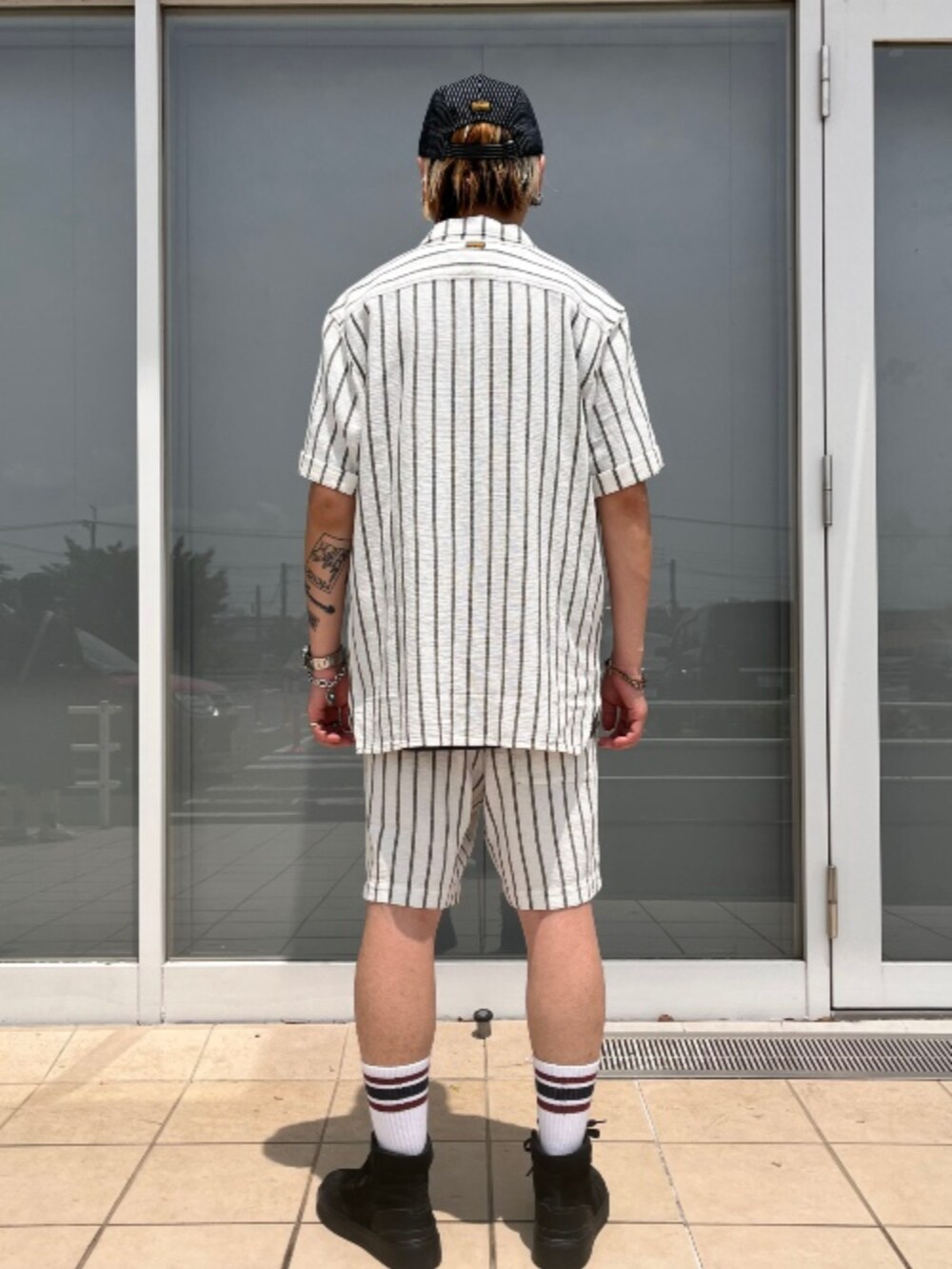 ホワイト系のシャツ/ブラウス、ホワイト系のその他パンツ、ブルー系のキャップを着用したメンズの夏コーディネートの2枚目の写真