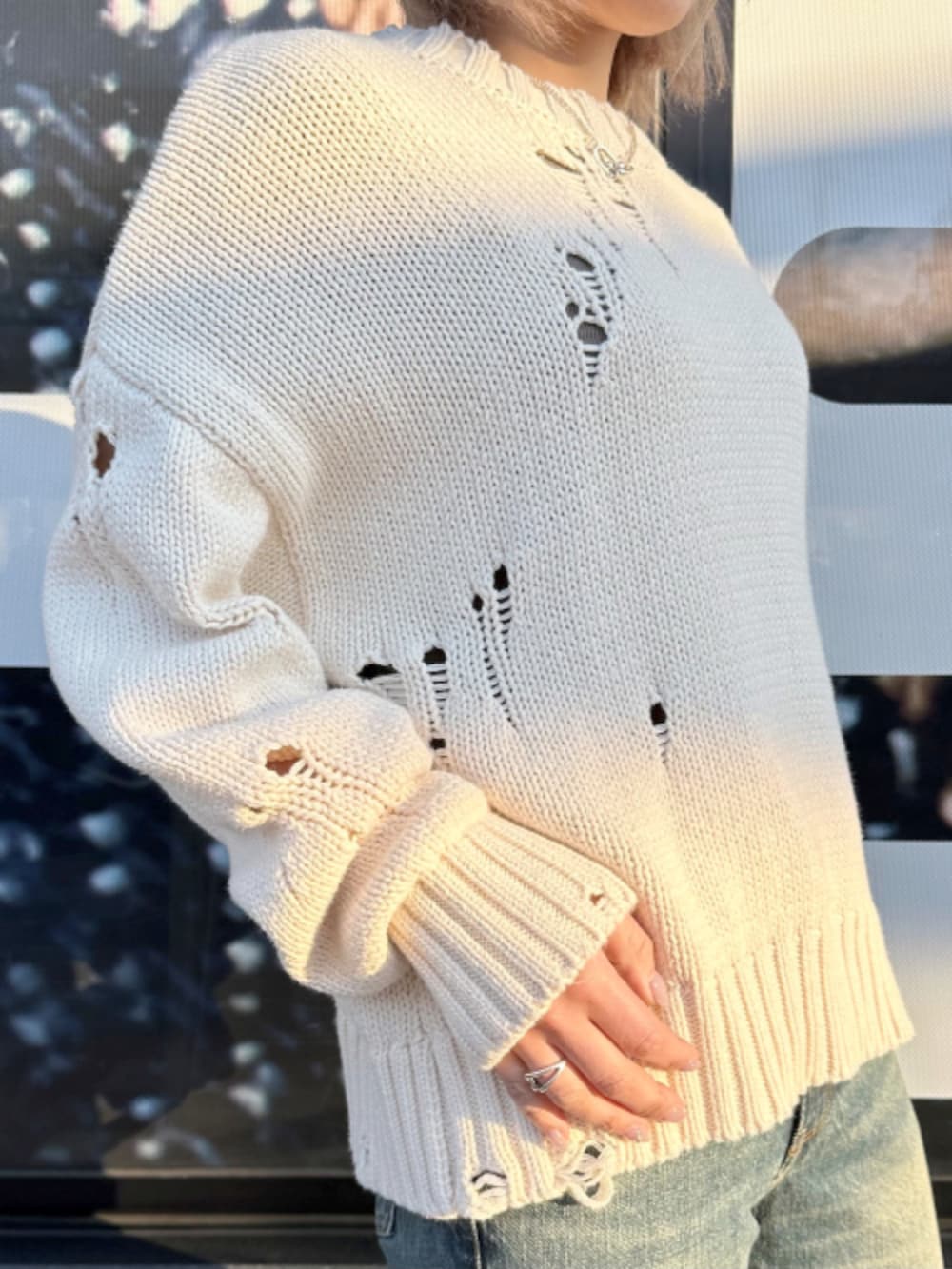 ベージュ系のニット/セーター、ブルー系のデニムパンツを着用したレディースの春コーディネートの2枚目の写真