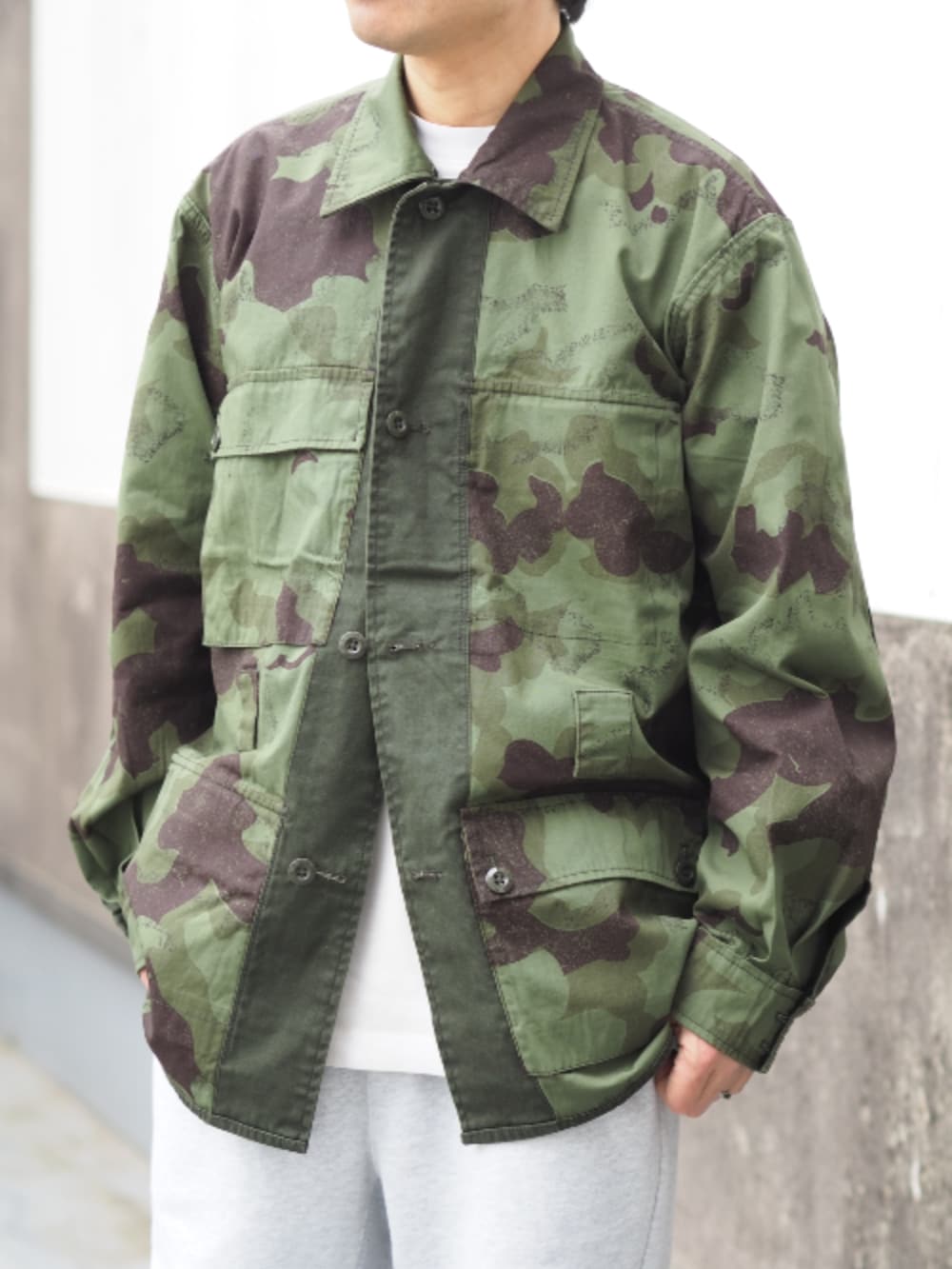 グリーン系のミリタリージャケット、グレー系のスウェットパンツ、ホワイト系のTシャツ/カットソーを着用したメンズの春コーディネートの3枚目の写真