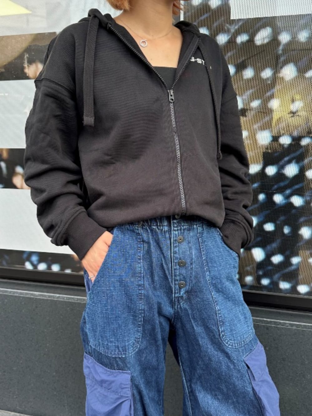 ブルー系のデニムパンツ、ブラック系のパーカーを着用したレディースの秋コーディネートの3枚目の写真