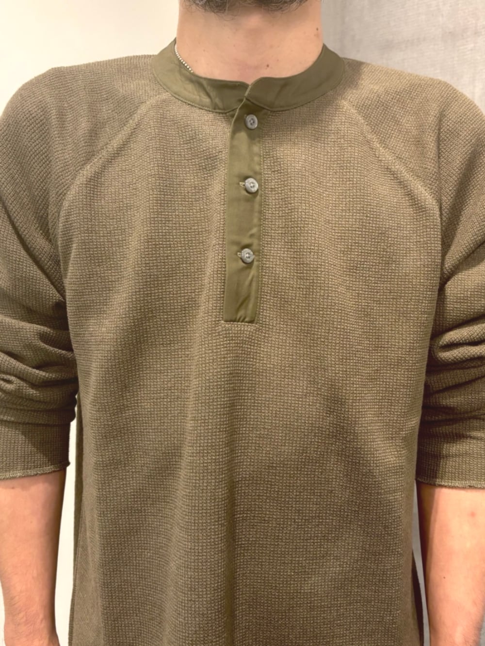 ブルー系のデニムパンツ、グリーン系のTシャツ/カットソー、ベージュ系のブーツを着用したメンズの秋コーディネートの2枚目の写真
